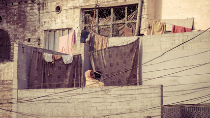 Curtains hanging on a clothesline with a woman holding a baby