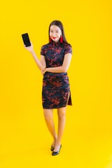 Portrait beautiful young asian woman wear chinese dress use smart mobile phone