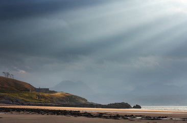 Fototapeta na wymiar Rays of autumn sunlight breaking through the cloud at the beach of Big Sand near Gairloch in the Scottish Highlands, Scotland, UK.