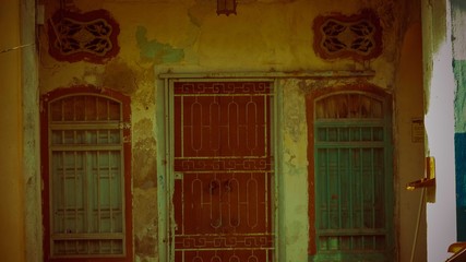 Grill door on a yellow wall with brown door