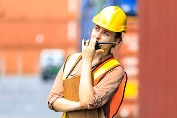 Professional foreman woman work at Container cargo site, harbor industrial import-export to loading...