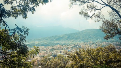 Fototapeta na wymiar Mountain view with the city next to trees