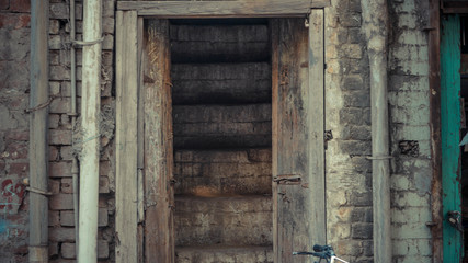 Opened wooden door with white brick walls