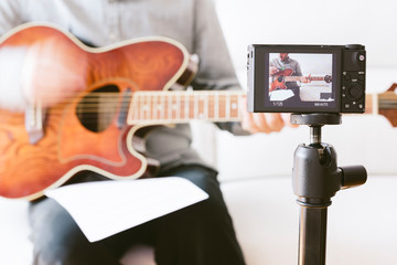 Adult playing guitar.Internet screen shot of music course. Home music recording online video class.selective focus