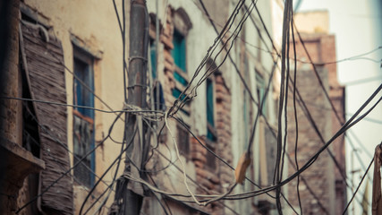 Fototapeta na wymiar Pole with wires tied to it with brick wall