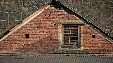 Fototapeta na wymiar Roof and brick wall with wooden window