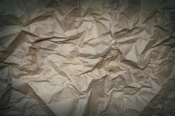 old crumpled craft paper background with vignette and copy space. paper texture