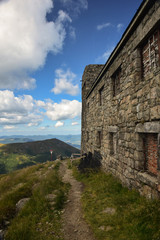 Fototapeta na wymiar Castle wall on top of a mountain, near path and mountain