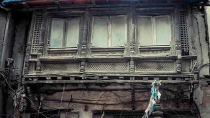 Rows of windows and wooden balcony with wires