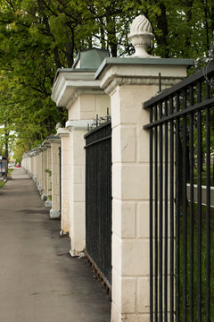 Metal fence, brick columns. Protections of buildings, parks.