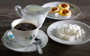 Hot tea style English and snack with sugar and fresh milk on gray wooden table