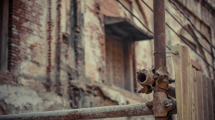Tall pole with wooden fence and brick wall