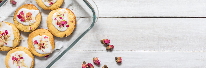 Home made rose short bread cookies on white wooden table top with copy space for text