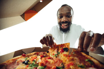 Amazing african-american man preparing unbelievable food with action, details and bright emotions,...