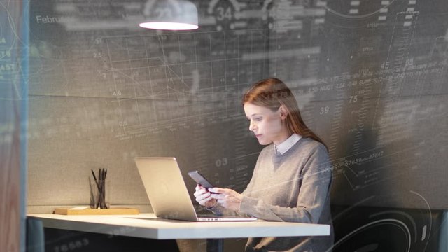 Businesswoman working alone in office using laptop and smart phone with infographics digital composite, futuristic, finance, technology