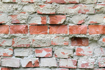 Old cracked brick wall with cracks and hollows. Grunge stylish background with grungy texture. Stock photo for web and print with empty space for text and design