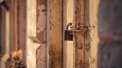 Wall and a wooden door with a padlock on it