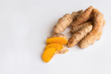 Turmeric root on white background. Tirmeric used as spice and treatment in alternative medicine with multiple benefits for health...