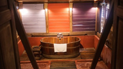 Wooden bath tub with white towel on top