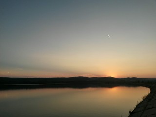 lake reflecting sunset with colored clouds in the forest