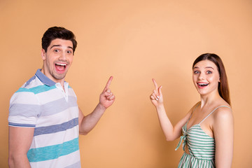 Photo of attractive lady handsome guy couple direct fingers empty space showing novelty sale shopping banner open mouth wear casual clothes isolated pastel beige color background
