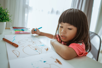 little girl asian drawing at home