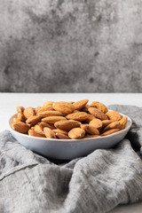 Almonds nuts on ceramic bowl. Roasted almond for snack
