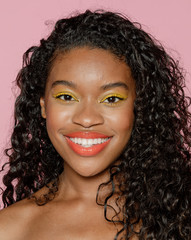 Happy black woman wearing yellow eye shadow