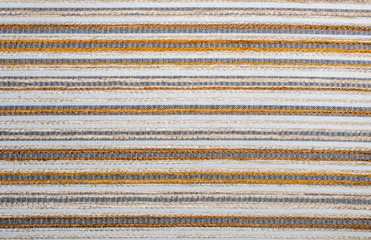 Detail view of decorative fabric texture with white, yellow, and black stripes