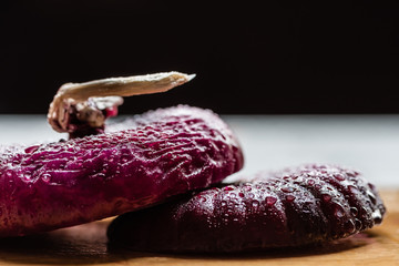 close up view of wet cut onion with water drops isolated on black