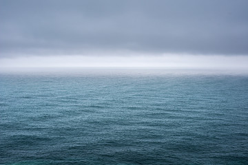 Minimalistic view of the sea with ripples under a dark gray sky