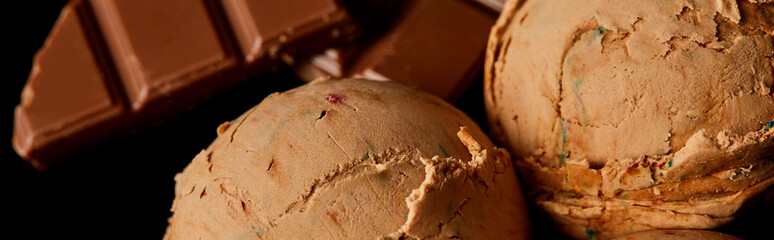 close up view of fresh delicious chocolate ice cream isolated on black, panoramic orientation