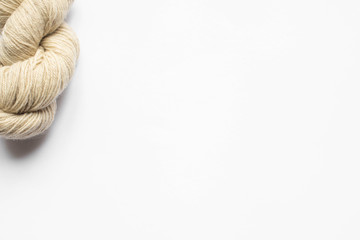 top view of beige yarn on white background with copy space
