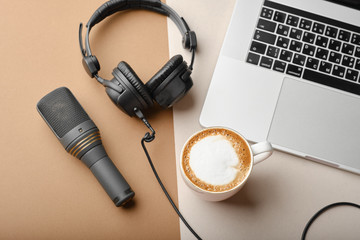 Flat lay composition with Microphone for podcasts  and black studio headphones on brown background with coffee and laptop, learning online education concept..