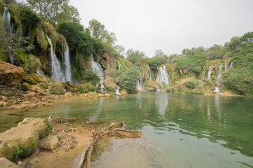 Fototapeta na wymiar Kravica waterfall is a large tufa cascade on the Trebižat River, in the karstic heartland of Herzegovina in Bosnia and Herzegovina. is a popular swimming and picnic area.