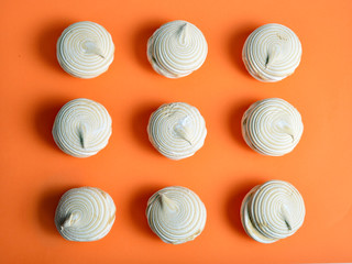Nine vanilla marshmallows on an orange background