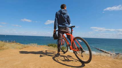 Young male on the bicycle with helmet ride on the beach 