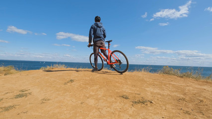 Young male on the bicycle with helmet ride on the beach 