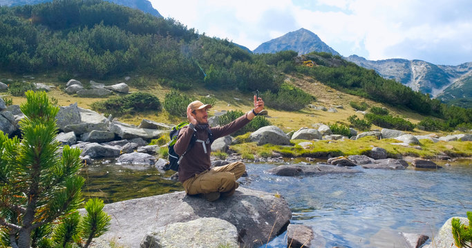 Yong Male Traveler In The Mountains Sitting Near River