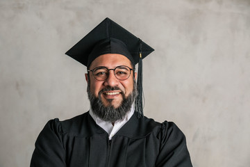 Proud senior man in a graduation gown