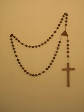 Rosary Beads Hanging On Brown Wall