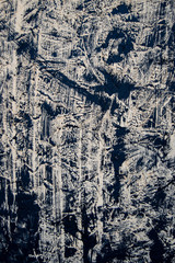 Texture background. The beige base is covered with smears of black paint. The view from the top. Texture and background