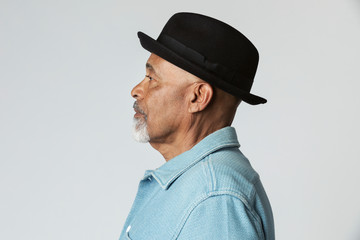 Stylish senior man wearing a black hat in a profile shot - Powered by Adobe