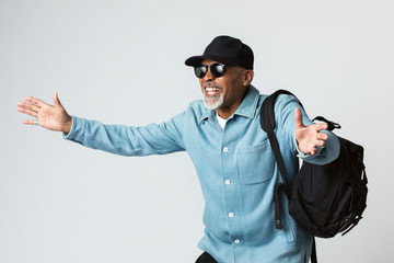 Cheerful black senior traveler wearing a cap