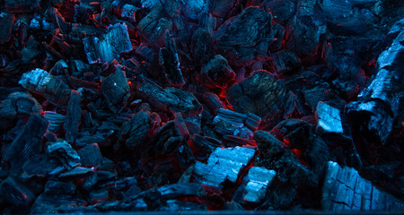 Burning coals in the dark, smoldering coal. Bright red sparks of fire. Background.