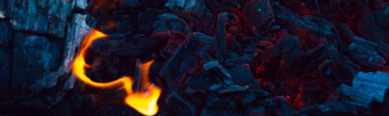 Burning coals in the dark, smoldering coal. Bright red sparks of fire. Background.	