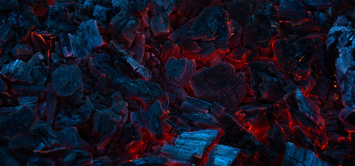 Burning coals in the dark, smoldering coal. Bright red sparks of fire. Background.	