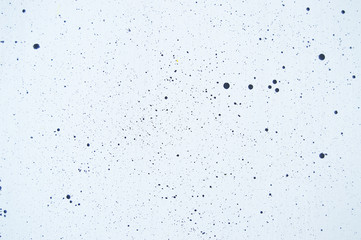 The background is white with black drops of different sizes all over the background.