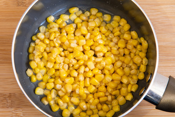 Fresh sweet corn in cooking pan. Top view of cooked maize in pot.