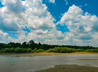 lake in the woods in summer time on sunny day with blue sky